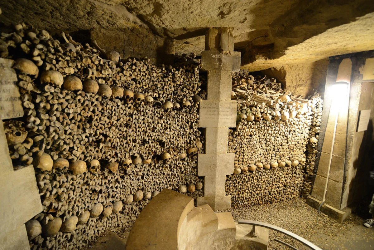 Walls of stacked skulls and bones in the ossuary of the Paris Catacombs
